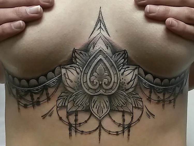 Black and grey ornamental mandala sternum tattoo