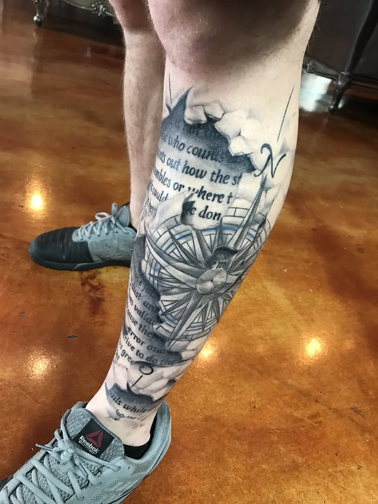 Black and grey leg sleeve with script and a compass