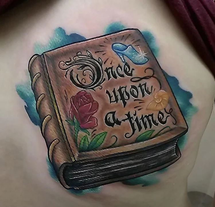 Color storybook tattoo reading Once upon a time, with roses