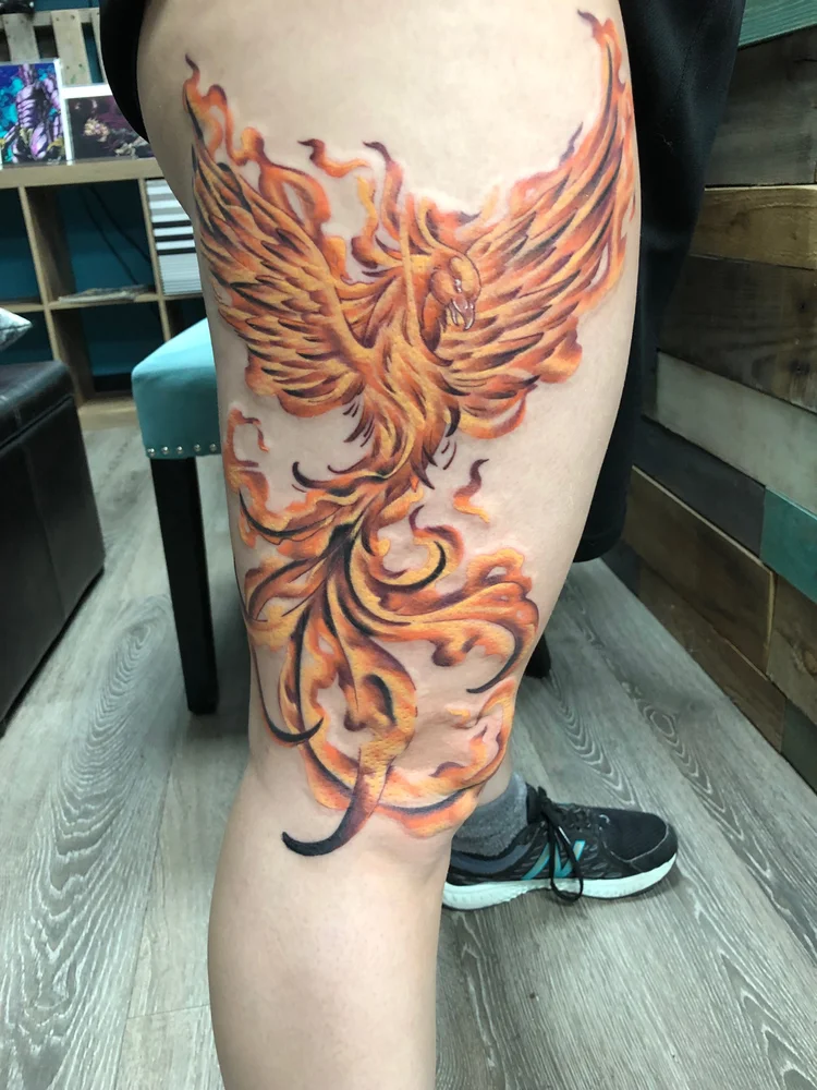 Color phoenix tattoo on the thigh