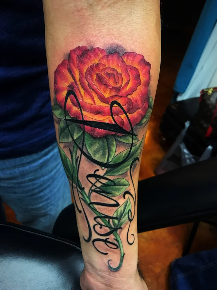Color rose with script lettering on the forearm